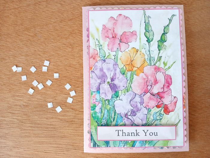 A photo showing the card topper and sentiment now attached to the pink card stock.