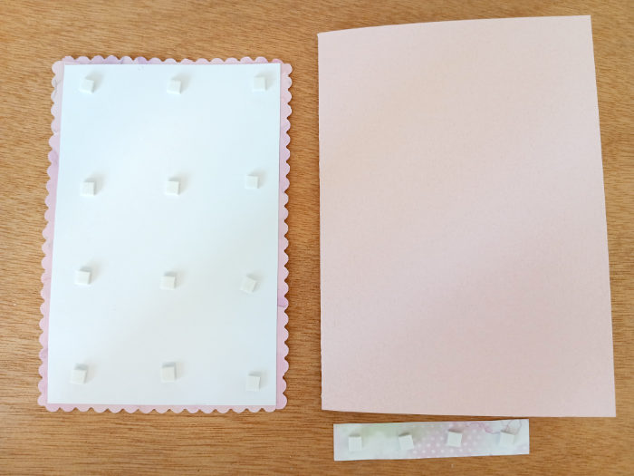 A photo showing the sticky foam craft pads attached to the topper and sentiment.