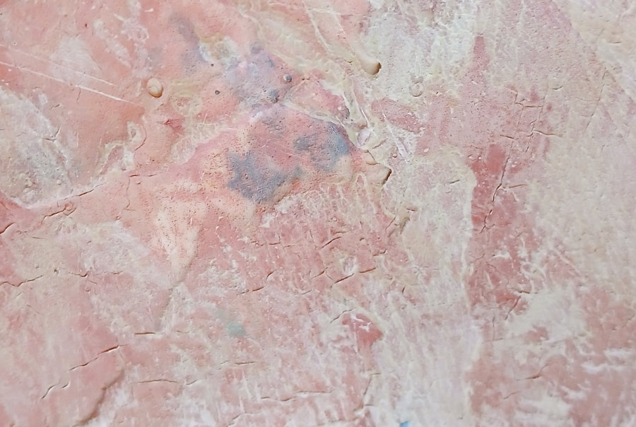 A close up of some of the textures created from the layers of ephemera and paint. The main colours are pale pink and white, with a small area of lilac.