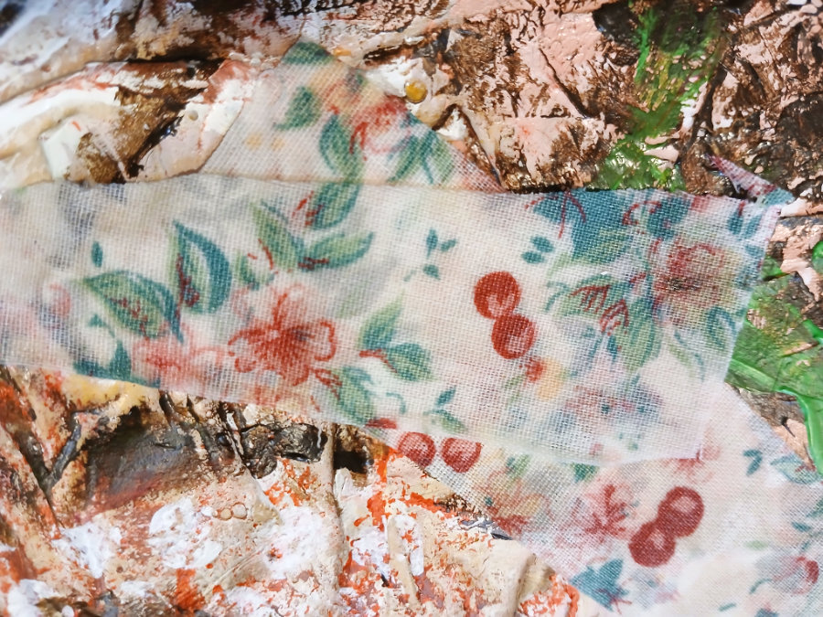 A close up of some scrap fabric that has been pasted to the substrate of one of the frog art pieces, another of the mixed media art techniques.