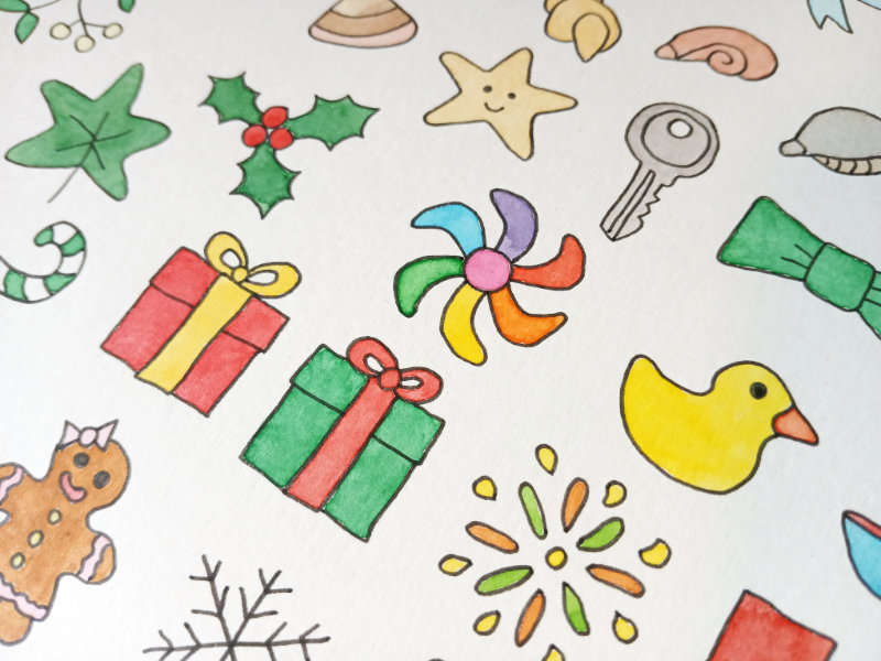 A close up of some of the colourful watercolour designs by Ruth Burton. There are illustrations of Christmas presents, toys, shells and fireworks.
