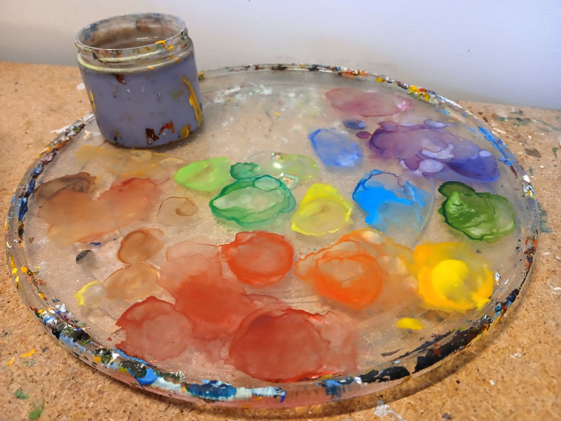 A paint palette of colourful watercolour paints mixed by Ruth Burton artist.