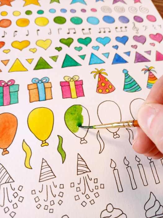 Ruth Burton painting a balloon illustration using green watercolour paint.